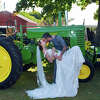 A photo opp in front of the big tractors at the 2022 Guilford Fair for newlyweds Andrew Hodge and Serena Weist-Hodge.