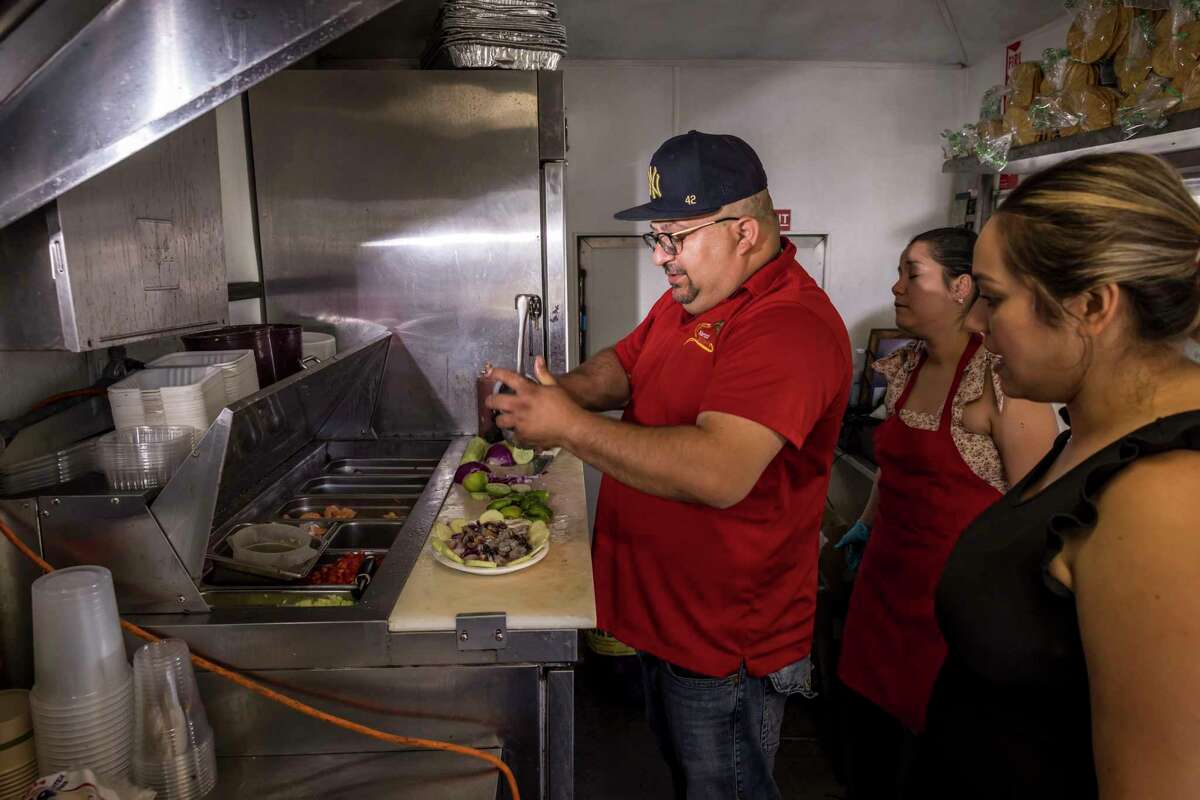 Jessica Osuna (right) watches her husband, Mario Bonilla, prepare a seafood dish inside their food truck Mariscos El Charco. The San Jose operation specializes in Mexican seafood in the Mazatlan style.