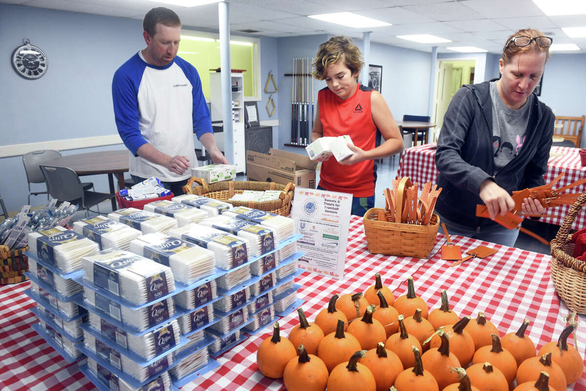 From left, volunteers Dave Record, Nate France and Kristine Saccone sort a wide variety of items to be given out during IMPACTrumbull’s Sweets and Treats event at the Trumbull Senior Center, in Trumbull, Conn. Sept. 26, 2022.