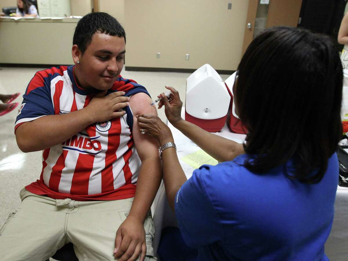Harris Health System's LaDonna Burley, R.N. vaccinates Jorge Arellano, 17, at North Forest High School where Harris Health System was vaccinating kids as they prepare to start school, Wednesday, July 31, 2013, in Houston. The Harris Health System has been vaccinating kids at several schools in advance of the beginning of school. ( Karen Warren / Houston Chronicle )