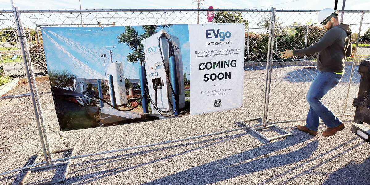 John Badman|The Telegraph Workers from eStructure Solutions on Monday erected a construction fence around the northeast corner of Oakwood Plaza on the Homer Adams Parkway for a planned EV charging station.
