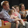 Jeffrey and Julia Horowitz, along with their children, Arielle, 3, Charles, 5, and Lily, 10 months, smile during a song at the Tot Holidays Rosh Hashanah program at Temple Sholom in Greenwich, Conn. Monday, Sept. 26, 2022. Artist-in-residence Sheldon Low led children and their families in prayer and song to introduce youngsters to the Rosh Hashanah holiday.