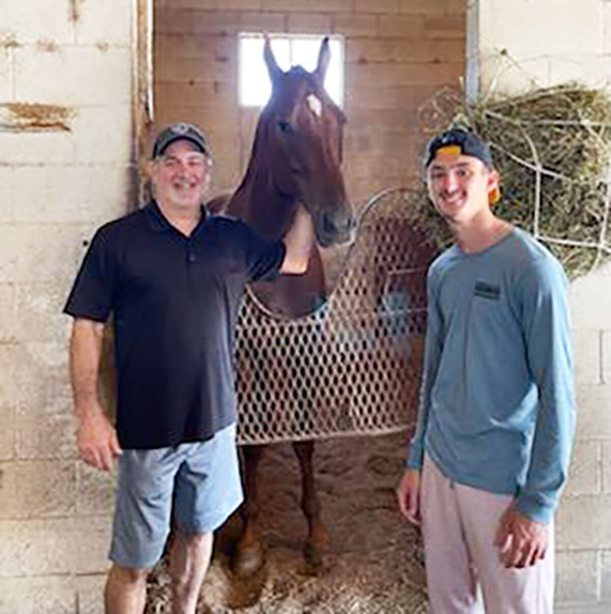 Edwardsville assistant hockey coach Rob Wiemers, left, with his stepson Cam Gillen at FanDuel Sportsbook & Horse Racing in Collinsville, with Wiemers’ horse Bam Bam Cam, who is named after Gillen.