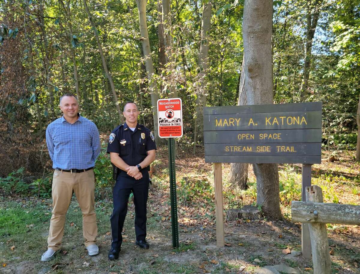 Conservation Department Director Tim Bishop and Police Chief Robert Kalamaras at the Mary Katona Open Space next to the sign Fairfield CARES helped get installed.