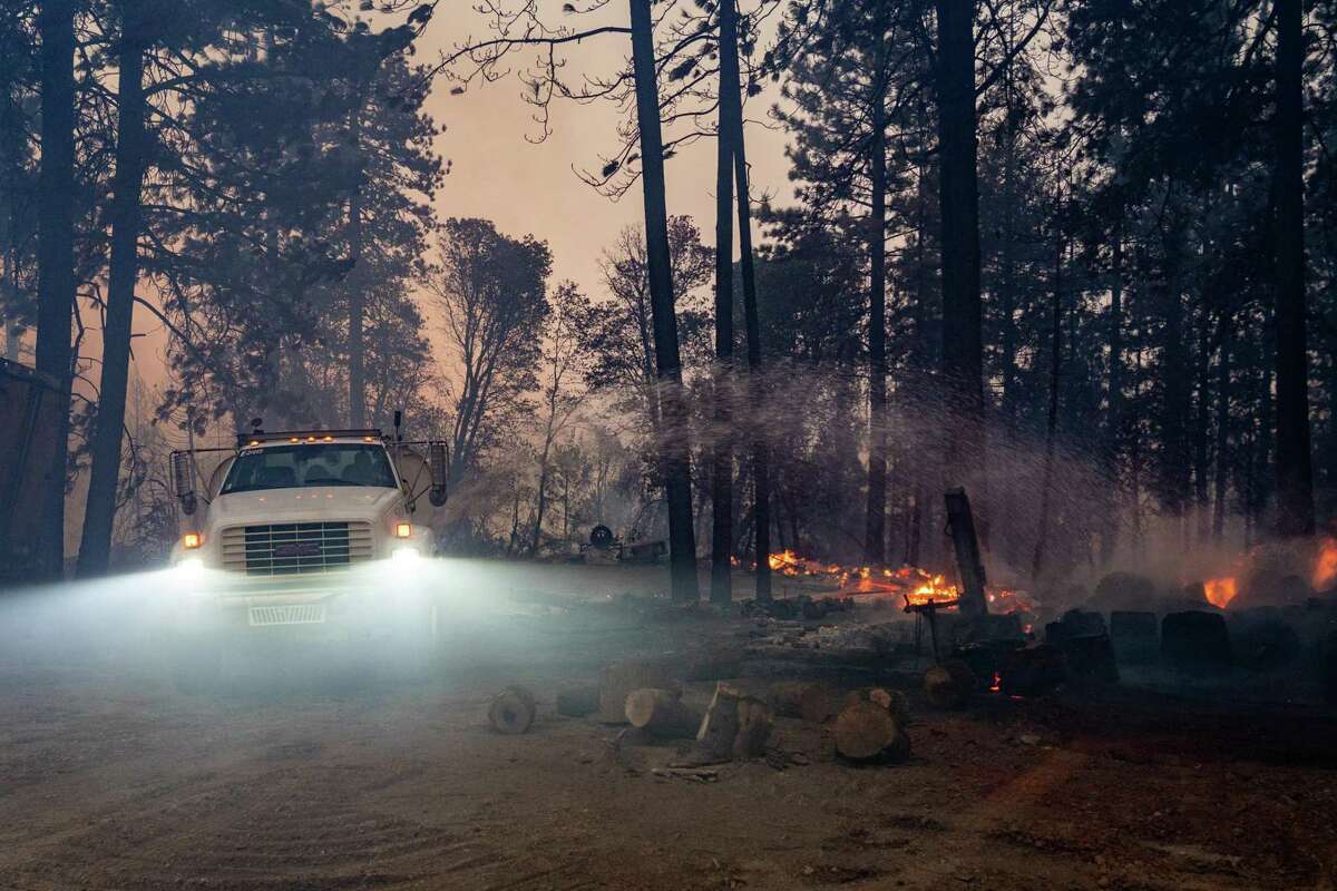 A truck sprays water to put out flames after the Mosquito Fire jumped the Middle Fork of the American River and burned structures and vehicles in Foresthill, Calif. Federal officials seized some of Pacific Gas & Electric Co.’s equipment as part of an ongoing criminal investigation into what started the fire.