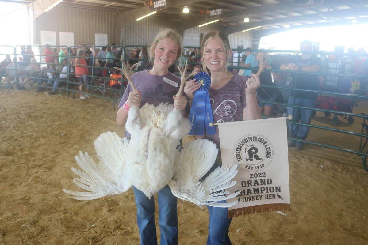 Addison and Hannah Sanders, representing the Deer Park High School FFA, pose with their grand champion turkey in the hen division after Monday's competition.