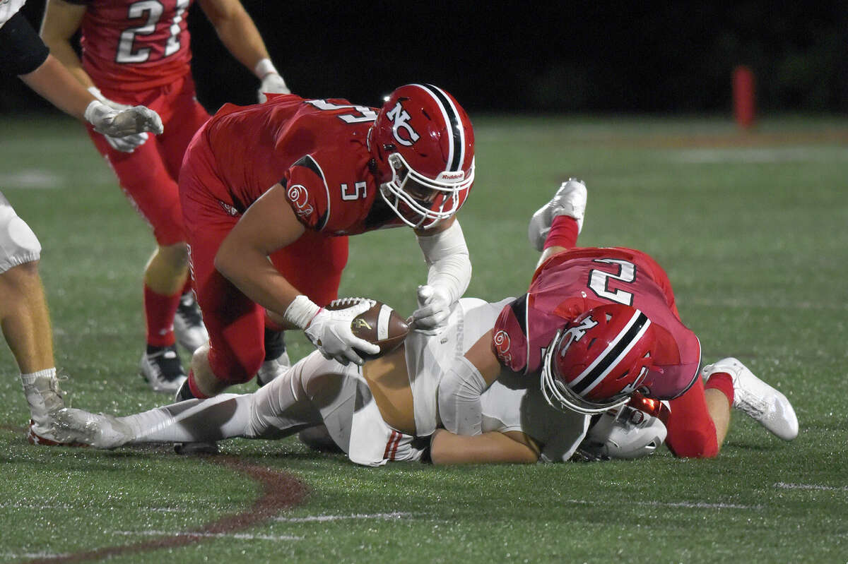 New Canaan's Matt Salmini (5) dives on the ball after a forced fumble by AJ Bell (2) during the Rams' football game against Fairfield Prep at Dunning Field on Friday, Sept. 23, 2022.
