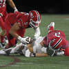 New Canaan's Matt Salmini (5) dives on the ball after a forced fumble by AJ Bell (2) during the Rams' football game against Fairfield Prep at Dunning Field on Friday, Sept. 23, 2022.