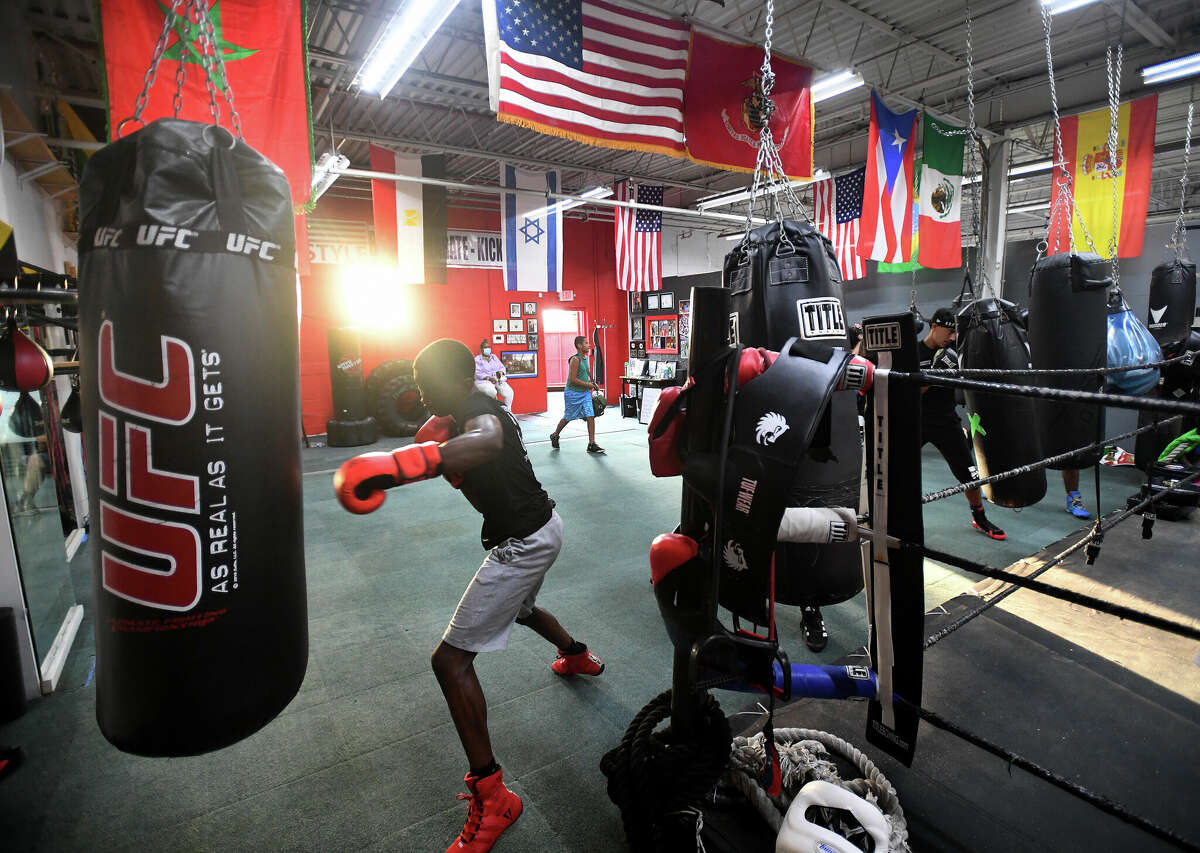 Christopher Alexis, 16, left, of Stratford, hits the heavy bag along with fellow boxers at the Chick Rosnick Boxing Club in Stratford, Conn. on Monday, August 16, 2021.