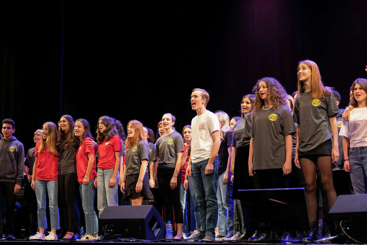 Students from Staples High School, King School, New Canaan High School and Darien High School perform "In Our Hands" onstage for the finale.