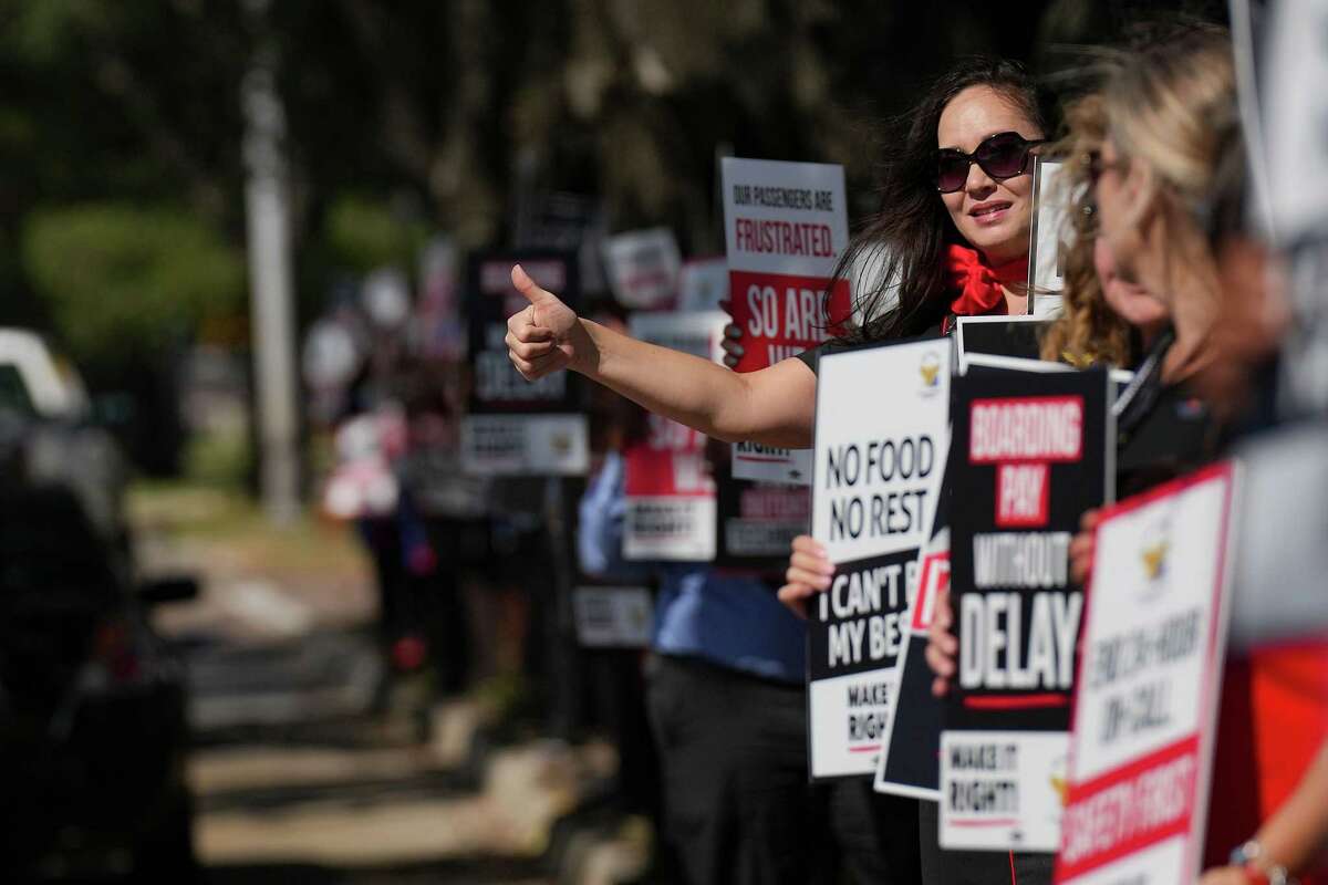 A Southwest Airlines flight attendant gives a thumbs up to cars driving by as she pickets with other members of TWU Local 556 picket near Hobby Airport on Tuesday, Sept. 27, 2022 in Houston. The flight attendants and supporters and negotiating a new contract with the demands of better pay, safety on the job and improved quality of life through a new contract.