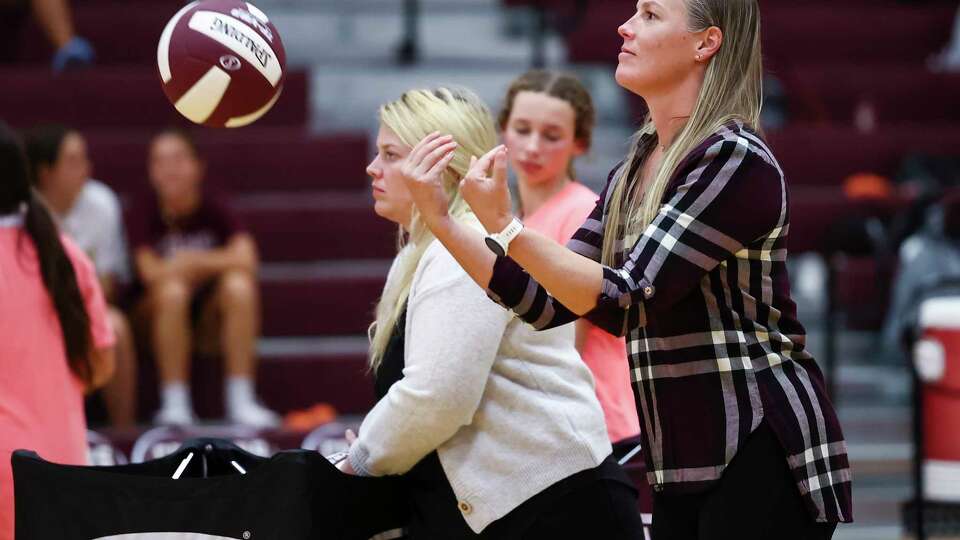 Cinco Ranch Head Coach Danielle Wells, tosses warm-up balls prior to the District 19-6A high school volleyball game between the Cinco Ranch Cougars and the Katy Taylor Mustangs at Cinco Ranch High School in Katy, TX on Tuesday, September 27, 2022.