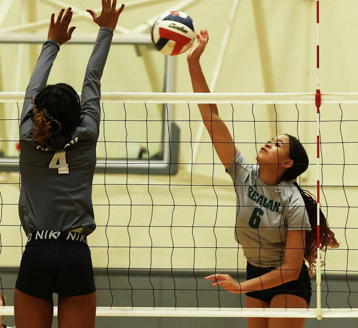 Reagan’s Aniya Hall, right, hits against Clark’s Ava Houston during their volleyball match at Littleton Gym on Tuesday.