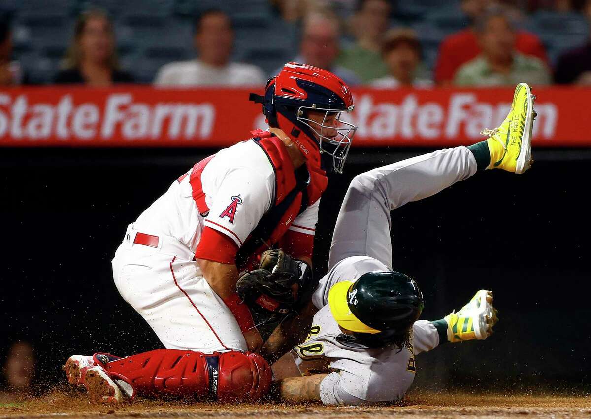 ANAHEIM, CALIFORNIA - SEPTEMBER 27: Matt Thaiss #12 of the Los Angeles Angels makes the out against Cristian Pache #20 of the Oakland Athletics in the second inning at Angel Stadium of Anaheim on September 27, 2022 in Anaheim, California. (Photo by Ronald Martinez/Getty Images)