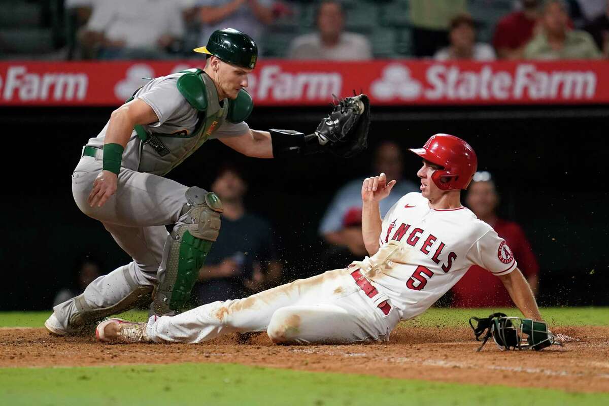 Los Angeles Angels' Matt Duffy (5) scores ahead of a throw to Oakland Athletics catcher Sean Murphy (12) during the eighth inning of a baseball game in Anaheim, Calif., Tuesday, Sept. 27, 2022. Duffy scored off of a single hit by Jo Adell. (AP Photo/Ashley Landis)