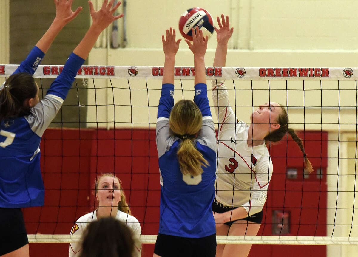 Greenwich's Katherine Ford (3) takes a shot while Ludlowe's Tatum Hoderied (17) and Clara Grosner (8) defend during a volleyball match in Greenwich on Tuesday, Sept. 27, 2022.