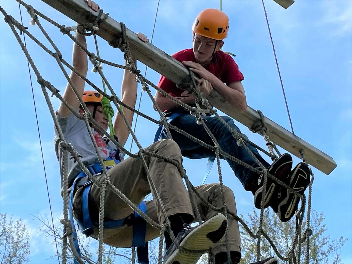Manistee Catholic Central students navigate the ropes course on Sept. 21 at Portage Lake Bible Camp in Onekama.
