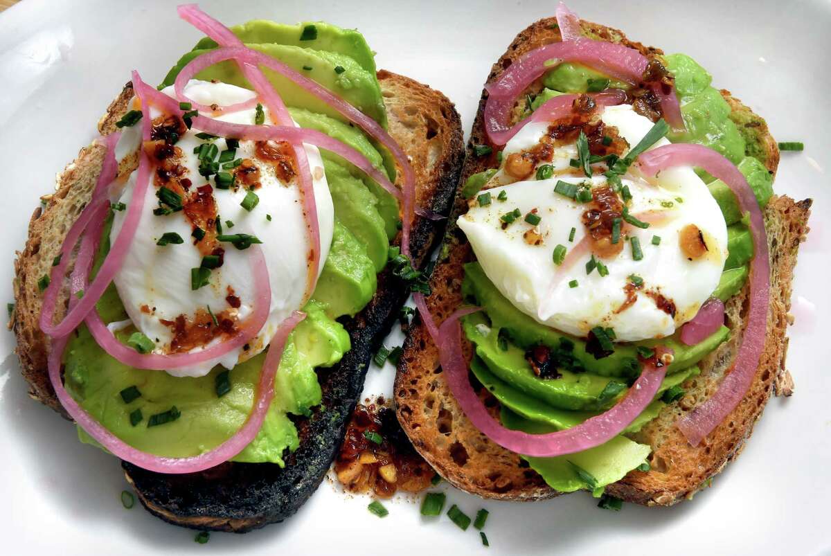 Avocado toast topped with poached eggs photographed at Poppy's Coffee + Kitchen on Whitney Avenue in New Haven on September 28, 2022.
