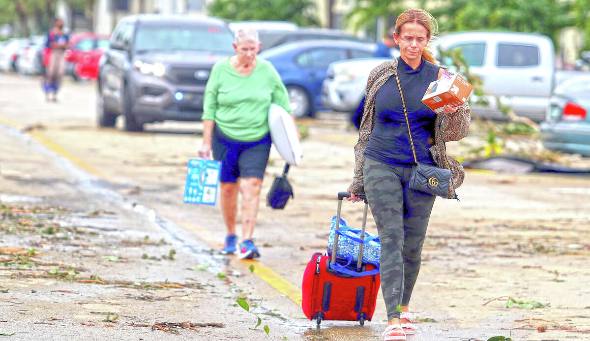 Residents leave with their belongings after an apparent tornado spawned from Hurricane Ian struck the Kings Point community in Delray Beach, Florida.