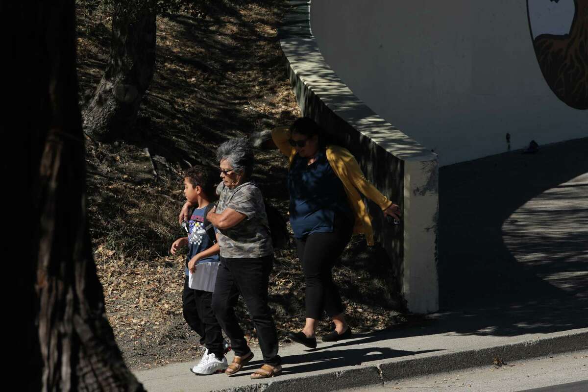A student is picked up and comforted by a loved one outside Oakland Academy of Knowledge near Sojourner Truth School, where an afternoon mass shooting occurred on Wednesday, September 28, 2022 in Oakland, Calif. Six shooting victims have been transported to area hospitals.