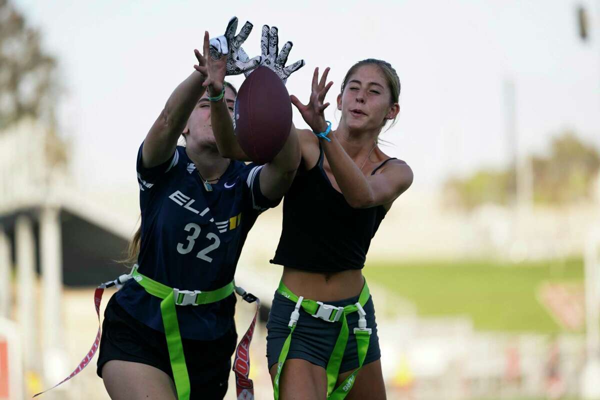 Aly Young, 17, left, and Shale Harris, 15, reach to catch a pass as they try out for the Redondo Union High School girls flag football team on Thursday, Sept. 1, 2022, in Redondo Beach, Calif. Southern California high school sports officials will meet on Thursday, Sept. 29, to consider making girls flag football an official high school sport. This comes amid growth in the sport at the collegiate level and a push by the NFL to increase interest. (AP Photo/Ashley Landis)