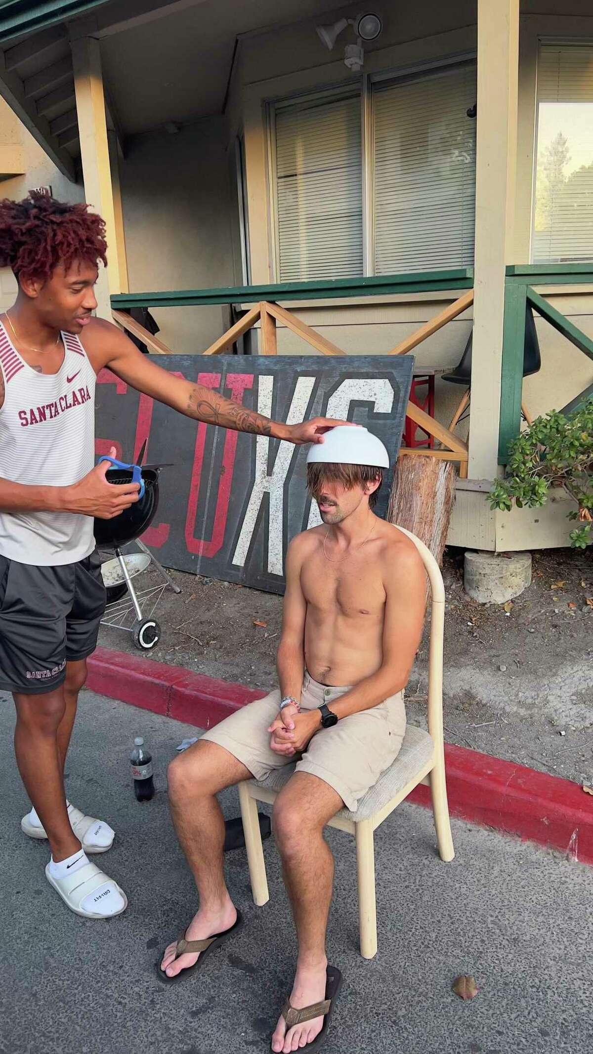 DeVon Dupree gives teammate Harvey Chilcott a bowl cut in preparation for the Santa Clara cross country team’s picture day.