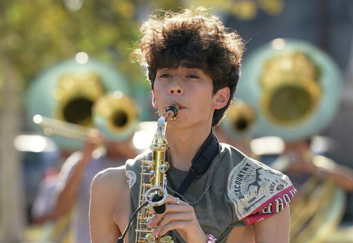 The Heights High School alto saxophone player Adrian Correa marches while rehearsing a performance Wednesday, Sept. 28, 2022, in Houston. The band was chosen to march in the Chicago Thanksgiving Day Parade, the only school in Texas selected for the honor.