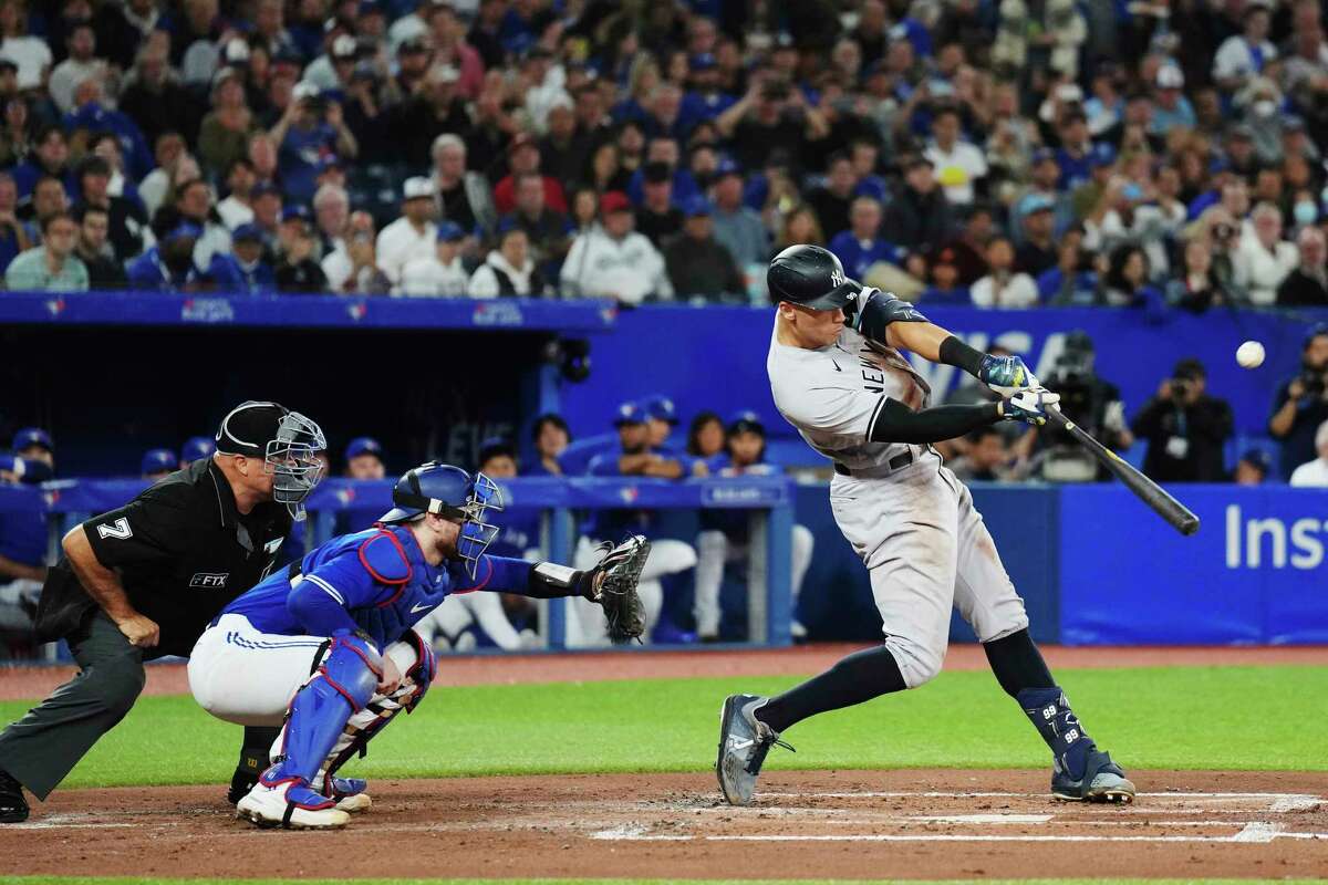 New York Yankees' Aaron Judge (99) flies out, next to Toronto Blue Jays catcher Danny Jansen during the second inning of a baseball game Wednesday, Sept. 28, 2022, in Toronto. (Nathan Denette/The Canadian Press via AP)