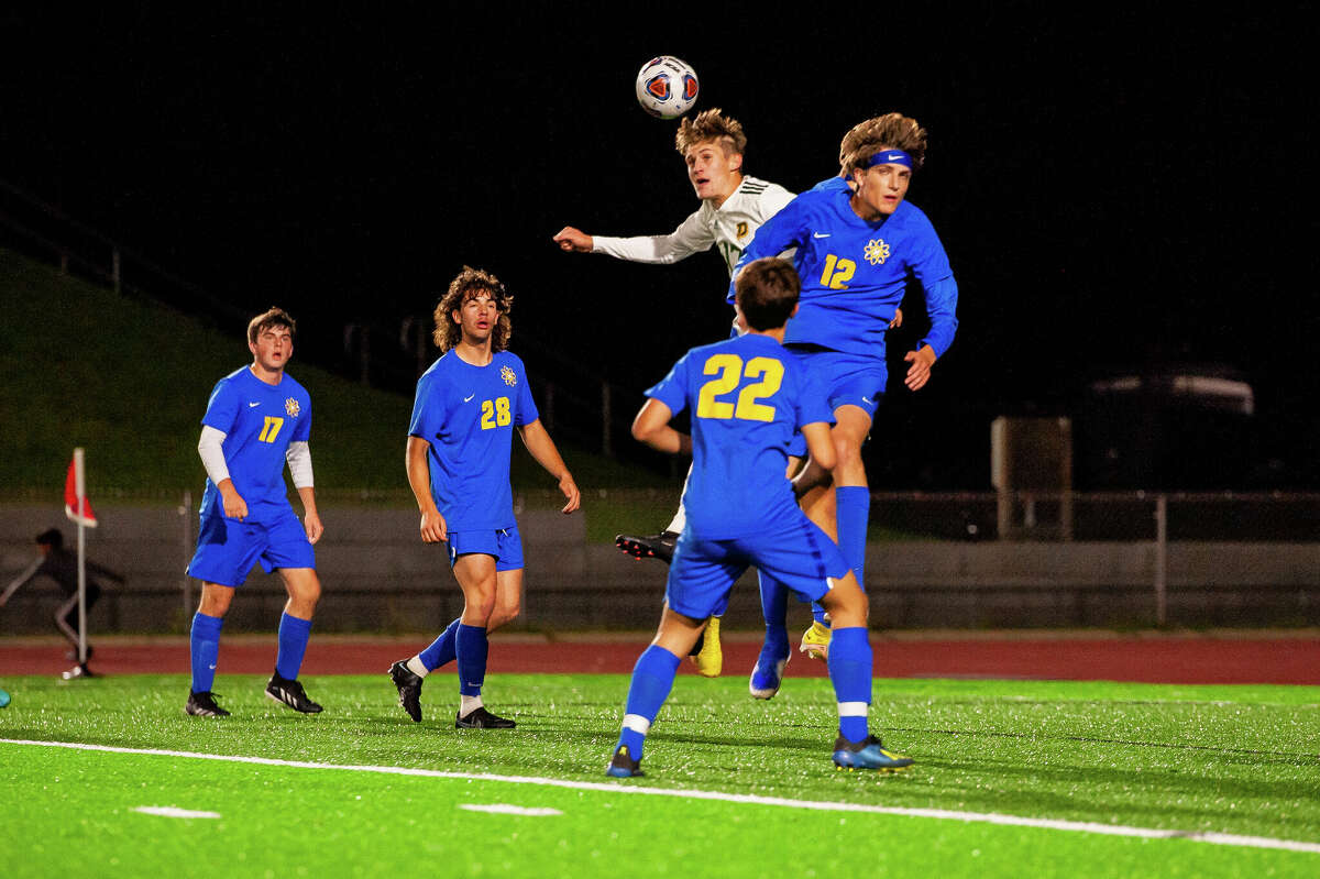 Midland High's Abe Haddad (12) goes up for a header against Dow High's Isaac Skinner during a Sept. 28, 2022 game. Haddad had a goal in Thursday's district quarterfinal win against Saginaw Heritage.