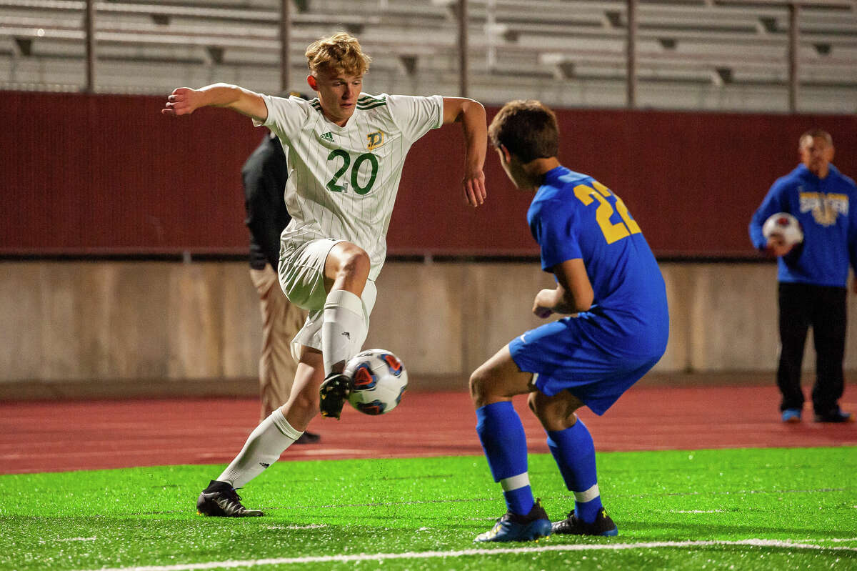 Dow High's Sean Hansen (20) tries to get by Midland High's Alfonso Cortez during Wednesday's game at Midland Stadium, Sept. 28, 2022.