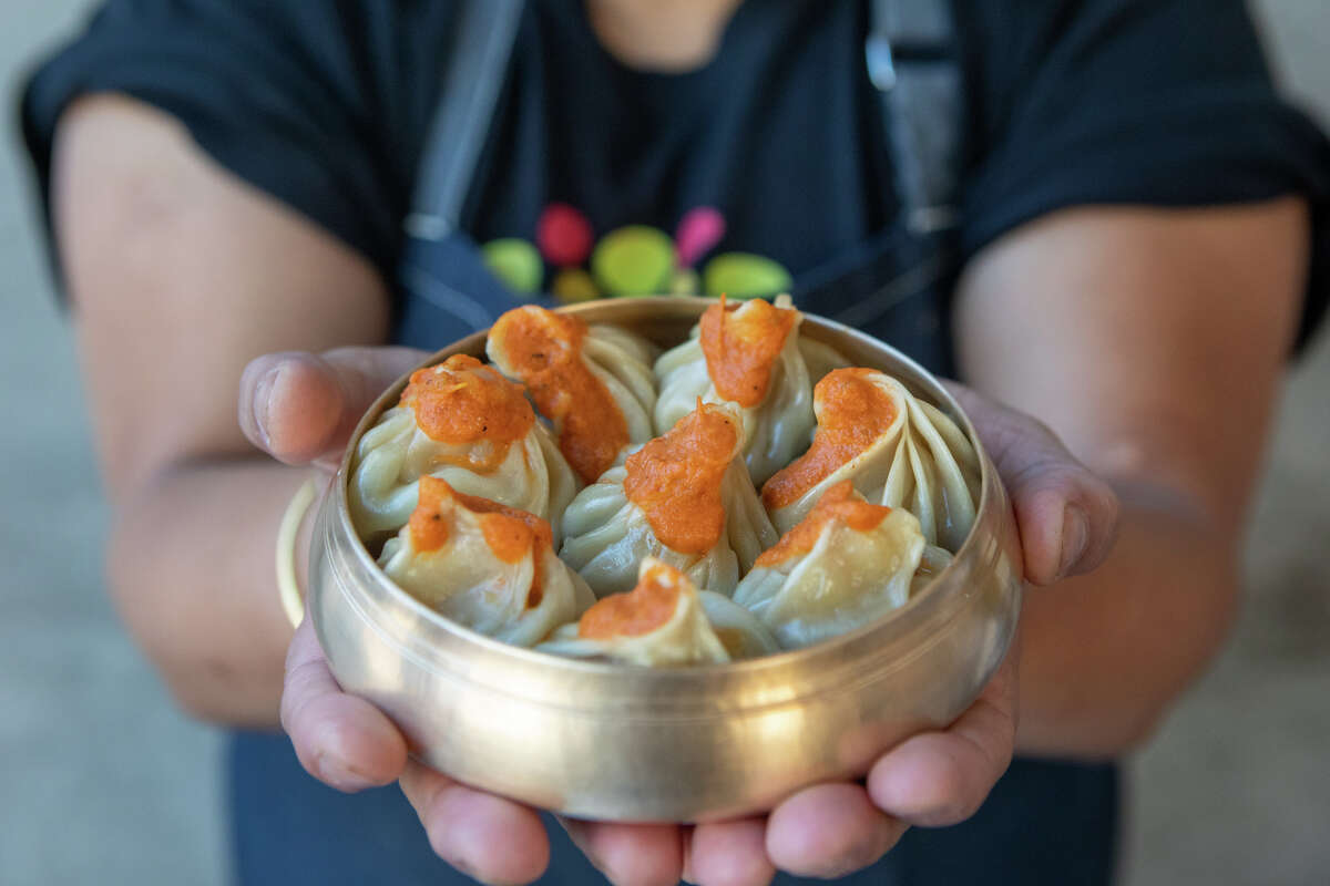 Binita Pradhan holds some lamb momos at Bini's Kitchen in San Francisco on Sept. 23, 2022. 