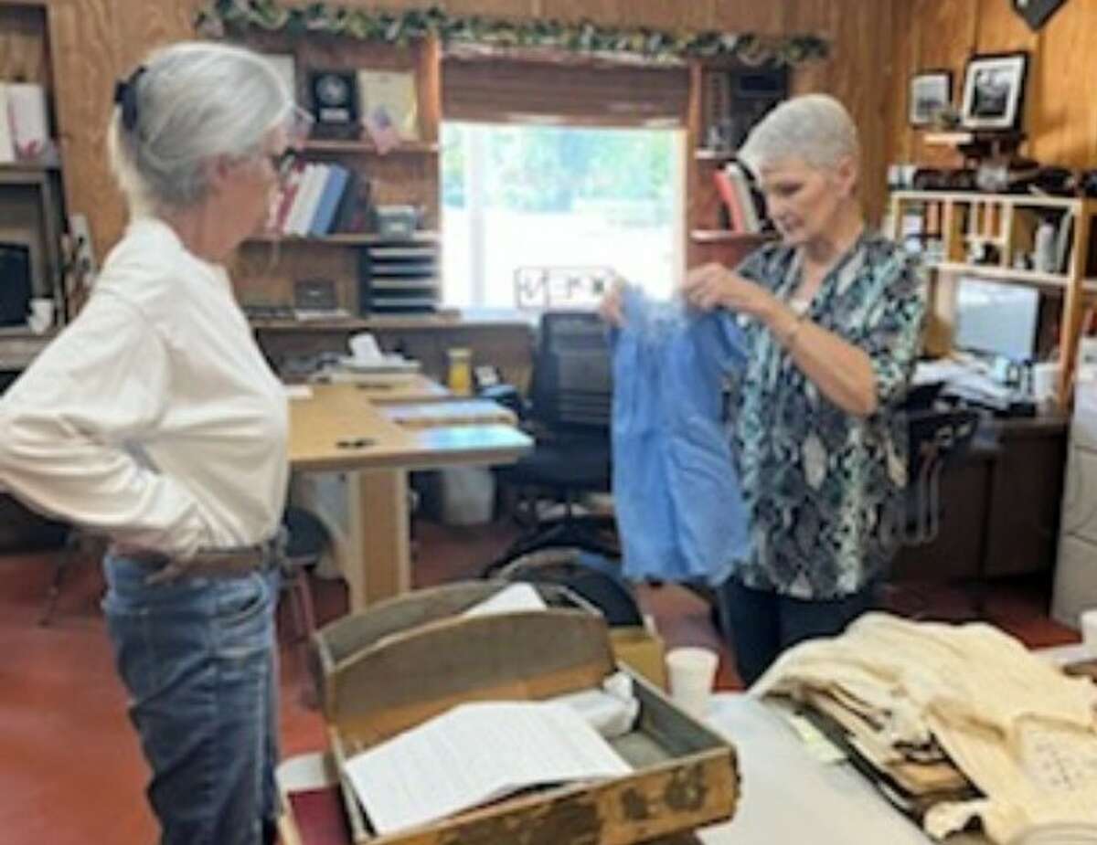 Nancy Kolb, from the Heritage Museum of Montgomery County, right, discusses the contents of a trunk that was donated to the Heritage Museum of Montgomery County with Susanne Waller, chairman of the Trinity County Historical Society. 