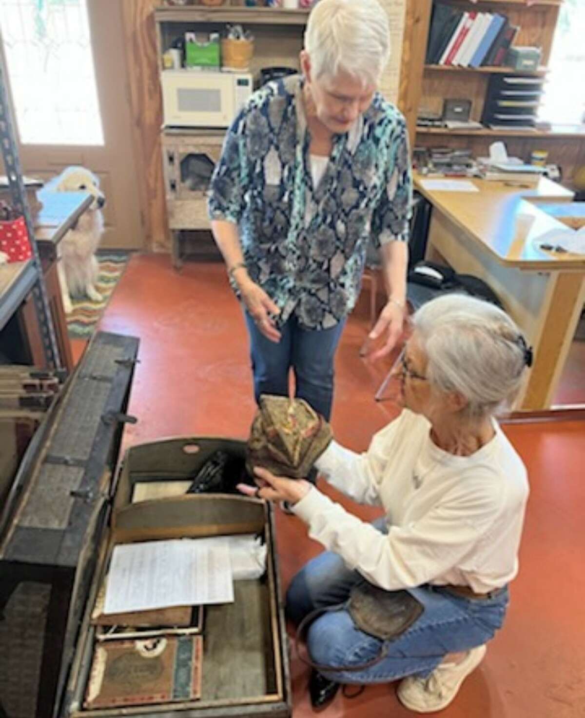 Nancy Kolb, from the Heritage Museum of Montgomery County, left, discusses the contents of a trunk that was donated to the Heritage Museum of Montgomery County with Susanne Waller, chairman of the Trinity County Historical Society. A group from Conroe took the trunk to the museum on Sept. 15. 