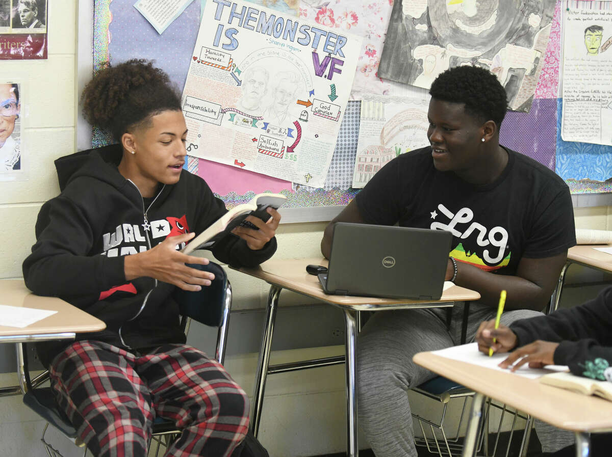 Seniors Aerrion Necatera, left, and Denzel Affun collaborate on a project together during English class at Westhill High School in Stamford, Conn. Thursday, Sept. 29, 2022. Stamford High School and Westhill High School implemented a new block schedule last month that means longer classes every other day instead of shorter classes every day. Teachers so far seem to really like the new system, but students are having mixed feelings about the longer classes.
