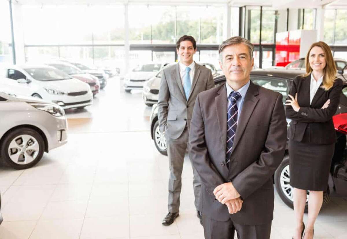 Car dealers standing in dealership