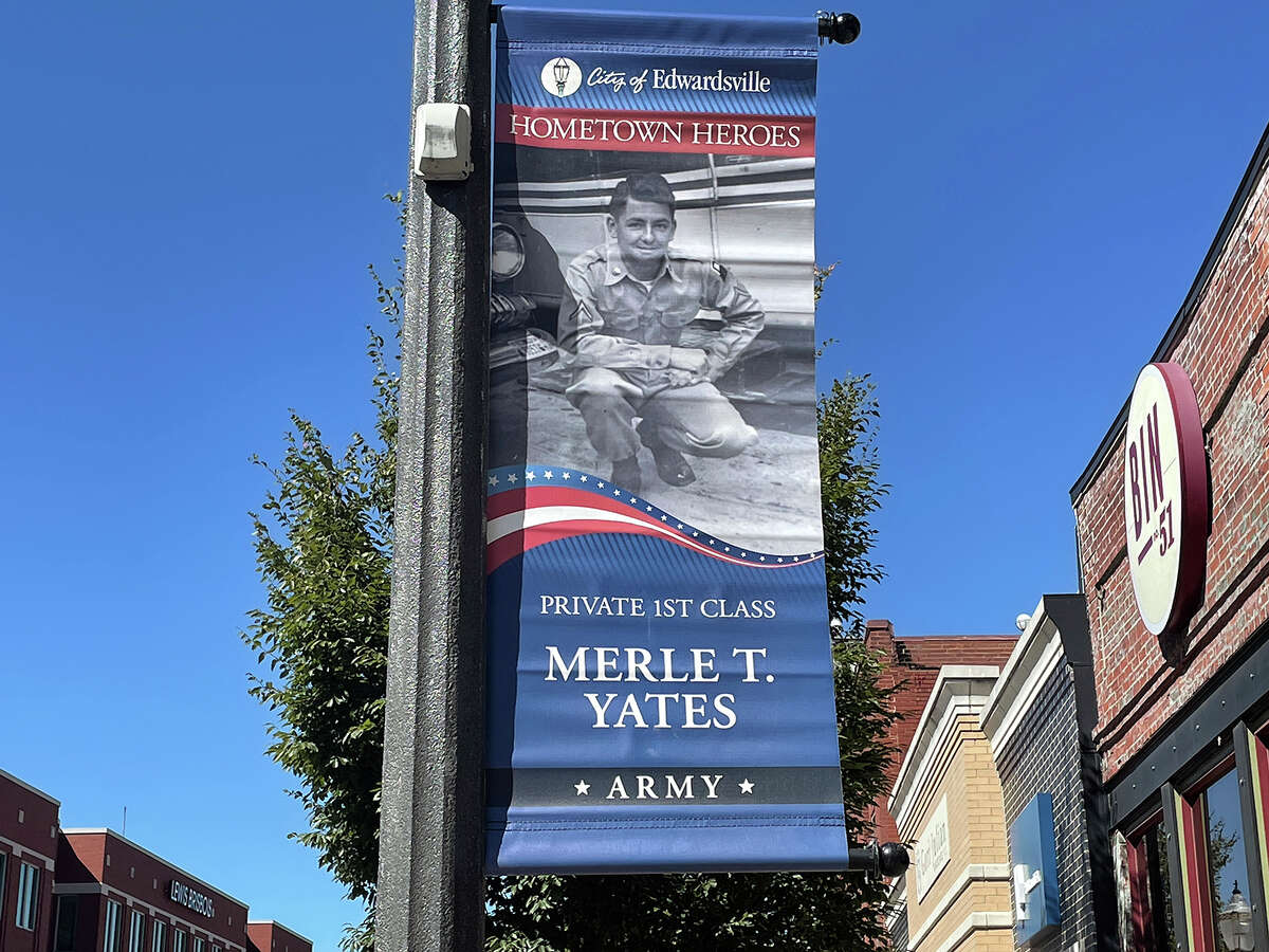 Merle T. Yates adorns another banner on North Main Street Thursday. Edwardsville has been hanging these banners for four years now, with more added every year. 
