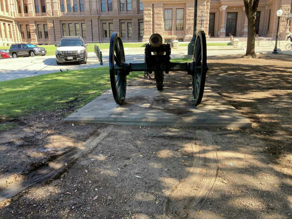 Tire tracks across the south lawn of the Texas State Capitol run up to a historic cannon, seen on Thursday, Sept. 29, 2022. A damaged perimeter fence, broken glass, a smashed sign and tire tracks marked a path of damage along the east entrance to the grounds.