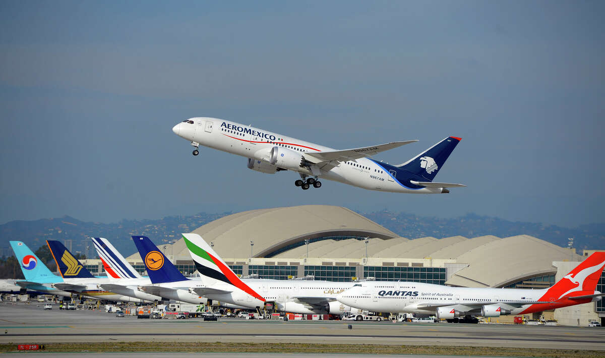 An AeroMexico jet takes off from LAX in January 2016 with five A380 jets and a 747 in the distance.