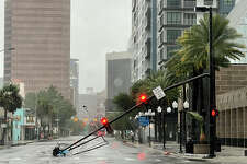 A stoplight pole blown down by Hurricane Ian winds, rests on Orange Avenue in Downtown Orlando, Fla., on Thursday, Sept. 29, 2022. Hurricane Ian has left a path of destruction in southwest Florida.