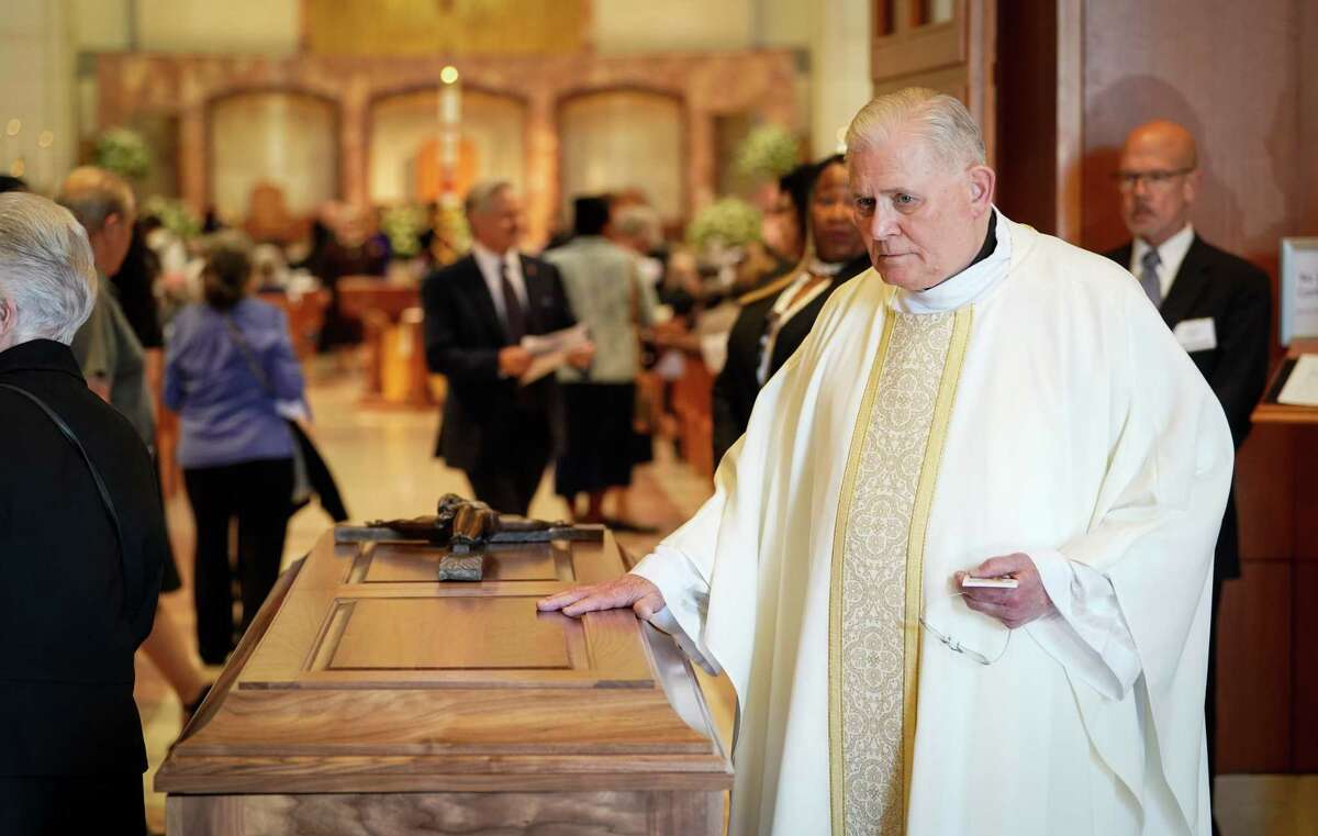 Father John Kappe, a retired priest from the Archdiocese of Galveston-Houston, touches the casket of Archbishop Emeritus Joseph Fiorenza before his funeral Mass Thursday at the Co-Cathedral of the Sacred Heart in Houston.