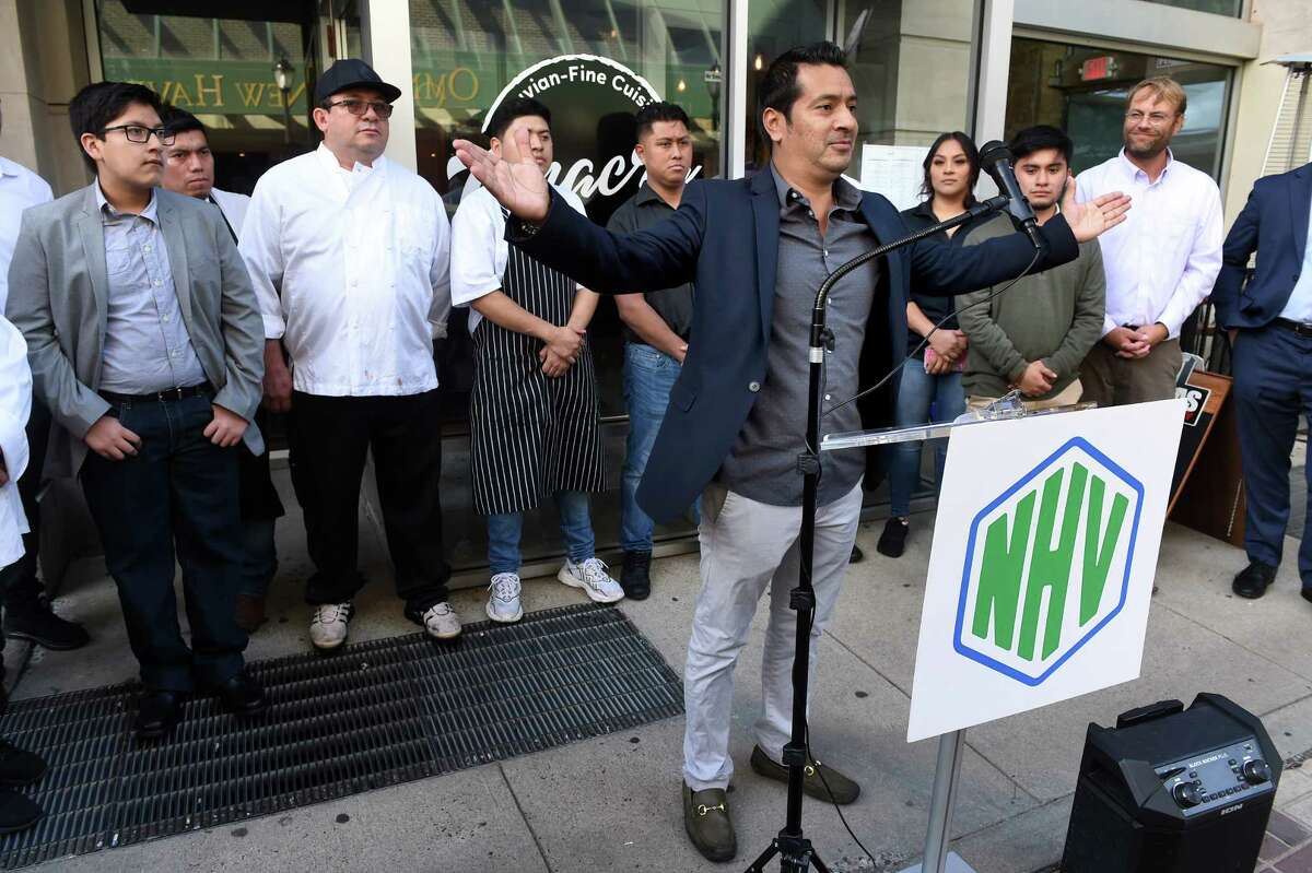 Walter 'Jefferson' Vera, center, speaks at a ribbon cutting to celebrate the opening of Chacra Peruvian Cuisine & Pisco Bar on Temple Street in New Haven on September 29, 2022.