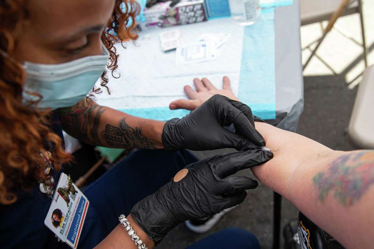 Registered nurse Elsa Tesfazghi administers a monkeypox vaccine Sunday to a Folsom Street Fair attendee in San Francisco.