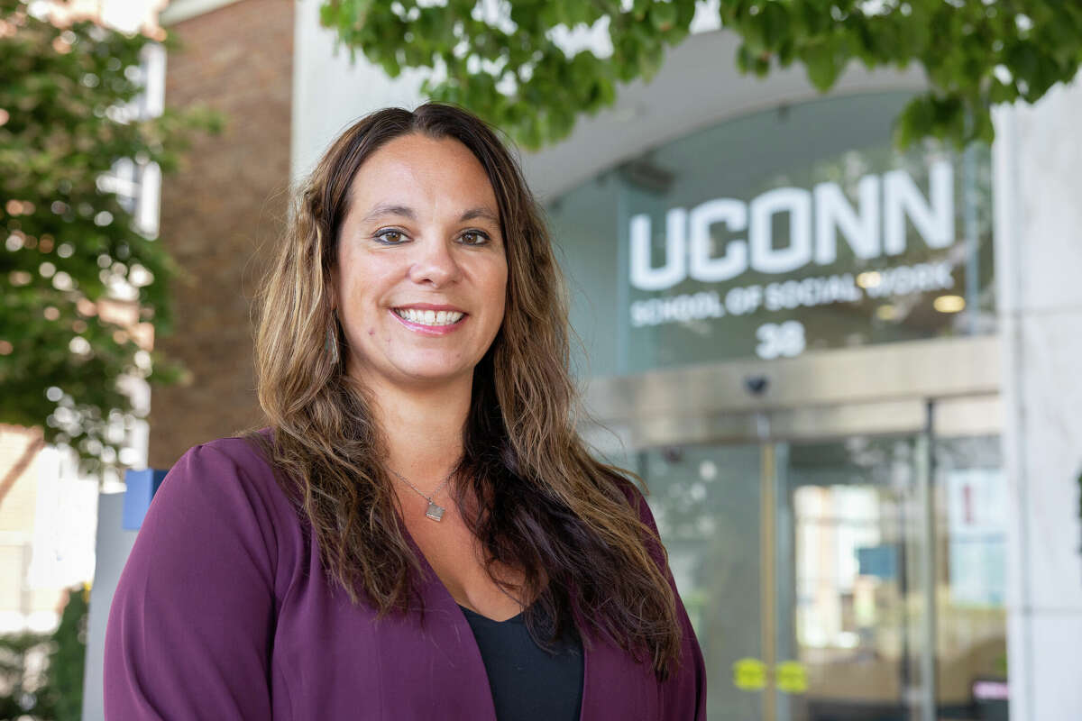 UConn School of Social Work professor Cristina Wilson poses for a photo in front of the School of Social Work Building on the UConn Hartford campus on Sept. 1, 2022. (Sydney Herdle/UConn Photo)