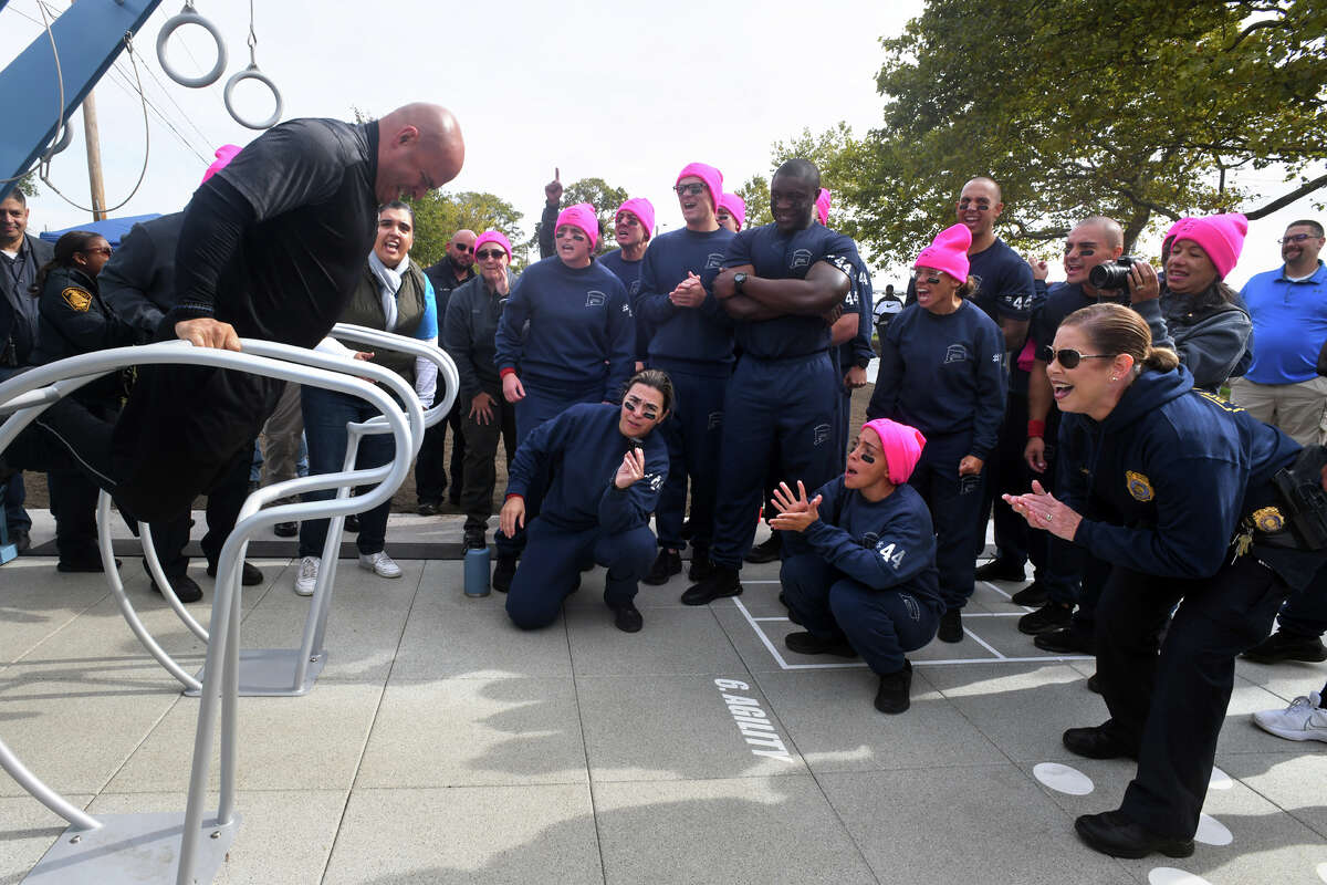 Police Academy instructor Juan Esquilin, left, takes part in a friendly competition between members and recruits of the Bridgeport Fire and Police Departments on the new outdoor fitness court at the West Beach section of Seaside Park, in Bridgeport, Conn. Sept. 30, 2022.