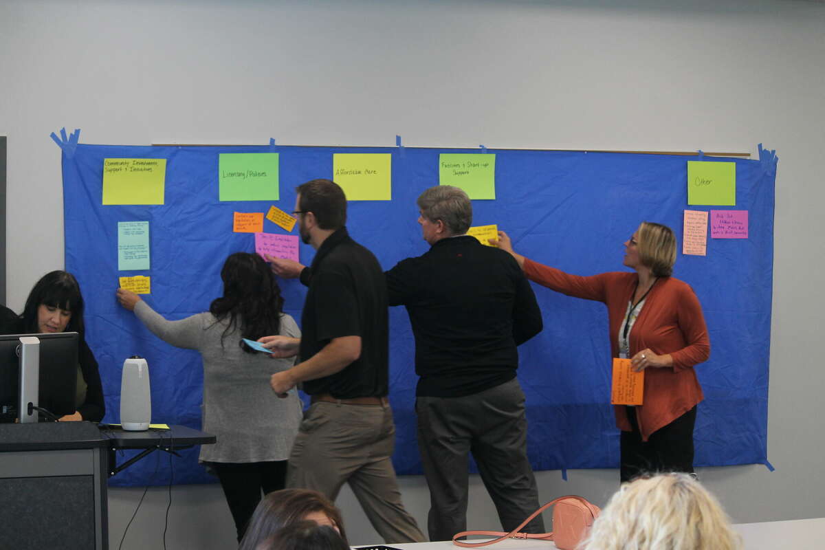 Community members place suggestions for what can be done to help improve access to affordable child care in Manistee County on a board Wednesday during a child care town hall meeting at the West Shore Community College Manistee Downtown Education Center.