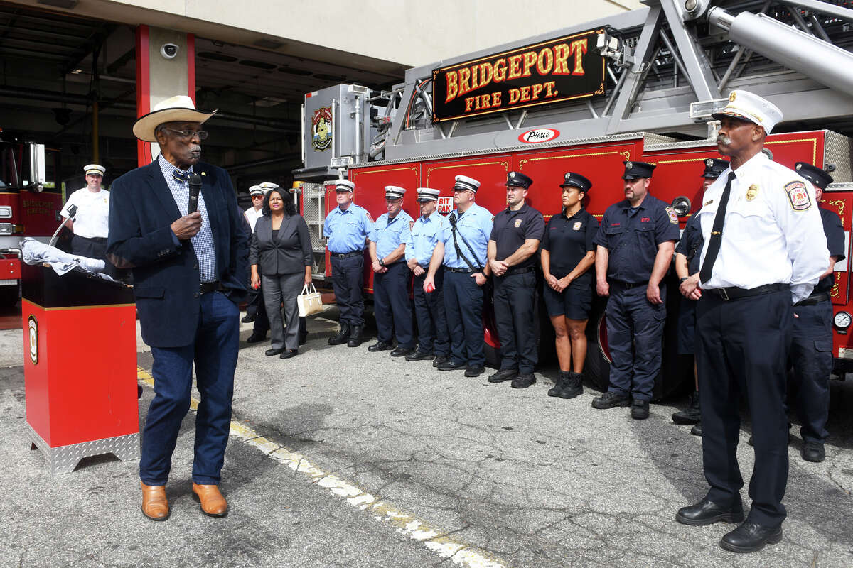 James Rawling, left, President and CEO of Sickle Cell Disease Association of American, Connecticut speaks to Acting Fire Chief Lance Edwards and members of the Bridgeport Fire Department during a check presentation at fire headquarter, in Bridgeport, Conn. Sept. 30, 2022. Members of the Bridgeport Fire Department collected over $18,000 for SCDAA during recent “Ring the Bell for Sickle Cell” boot drives.