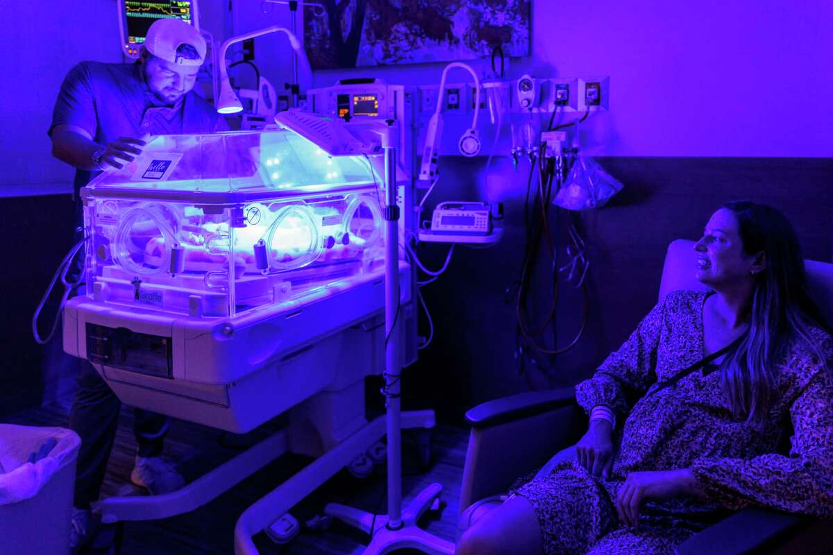 Danny Oldani checks in on his daughter, Kole, the middle-born triplet, as his wife, Mandi Oldani, watches her wiggle around Friday, Sept. 30, 2022, inside the NICU unit at Resolute Health Hospital in New Braunfels. The couple had their triplets — Baylor, Kole and Boston — on Tuesday, Sept. 27.