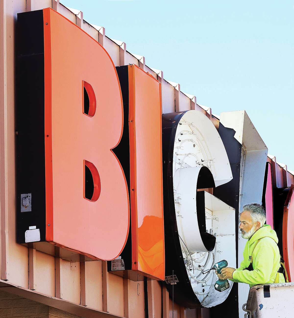 John Badman|The Telegraph An employee of Simon Sign Erection Co. in St. Louis had a big job Friday as he worked on the letter G from the Big Lots store sign at 1751 Homer Adams Parkway in Alton. Behind the orange plastic letters the sign is lit by neon tubing which needed repairs.