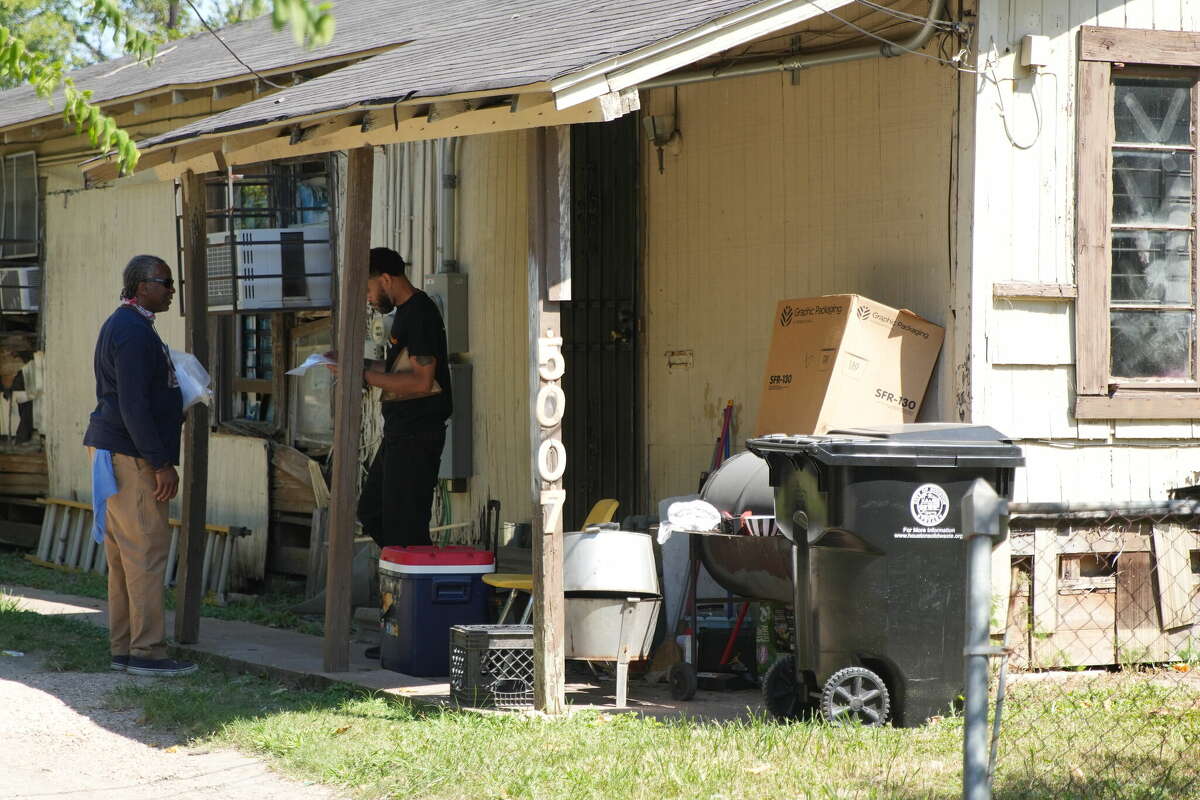 Volunteer Walter Mallett talks to a neighbor has he passes out flyers from the EPA on the porch of a home nearwhere testing found dioxins in samples stemming from the Union Pacific rail yard on Thursday, Sept. 29, 2022 in Houston.