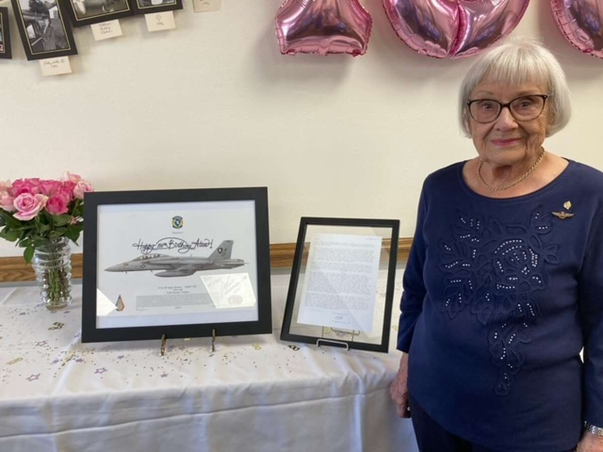 PLAINVIEW, Texas (Sept. 24, 2022) Alice Starnes poses for a photo with mementos presented to her during a celebration of her 100th birthday. Starnes served in the WAVES during World War II using the Link Trainer, one of aviation’s first flight simulators, to train more than 1,000 pilots to fly without the use of visual references. (U.S. Navy Photo Courtesy of the Starnes Family)